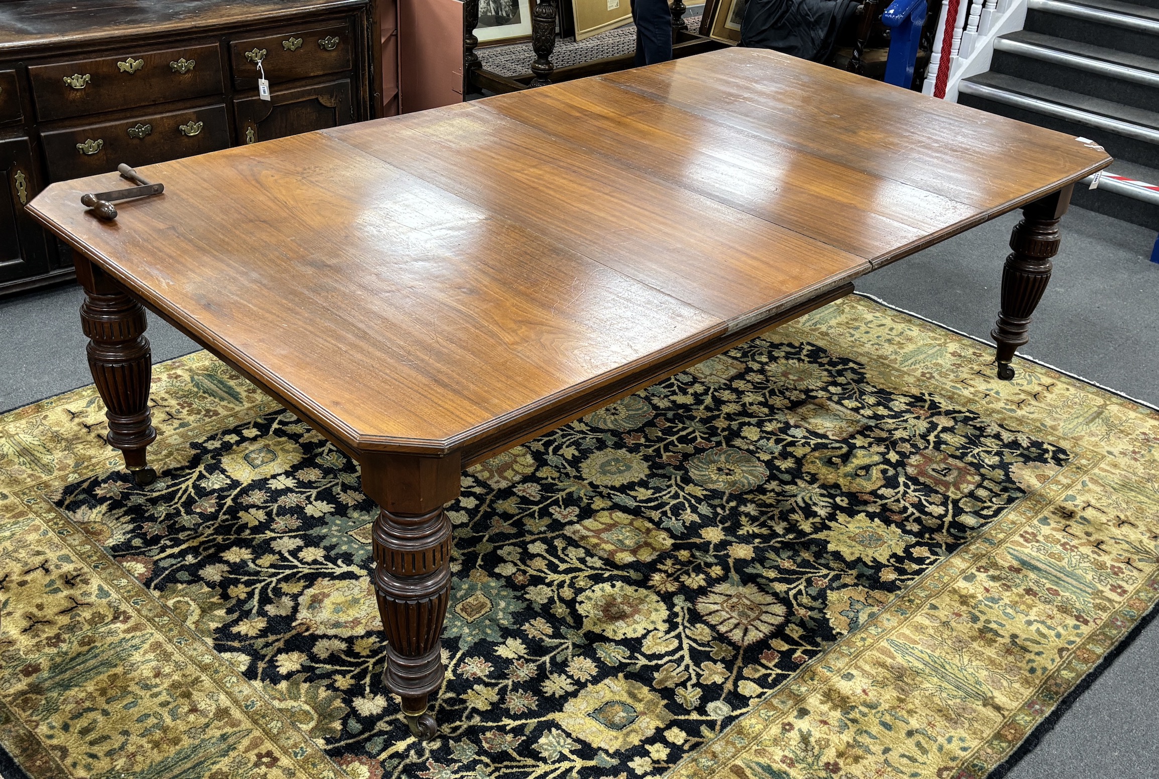 A late Victorian walnut extending dining table, on turned fluted baluster legs, 240cm extended, two spare leaves, depth 137cm, height 73cm